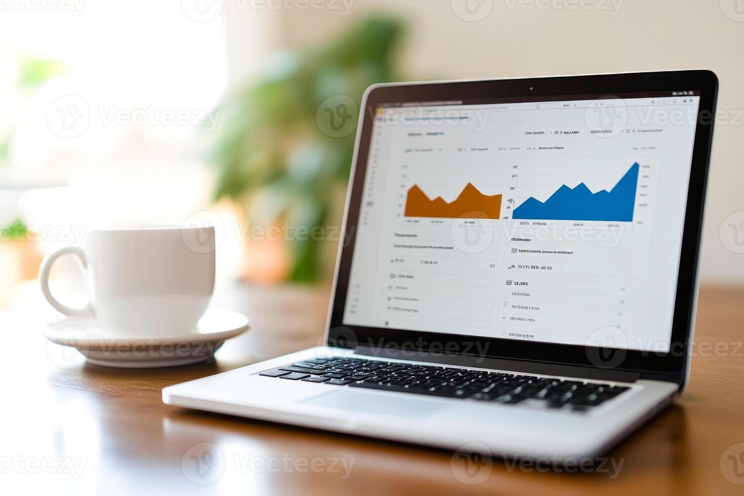 Laptop displaying charts and graphs beside a coffee cup in a bright, modern workspace during the morning photo