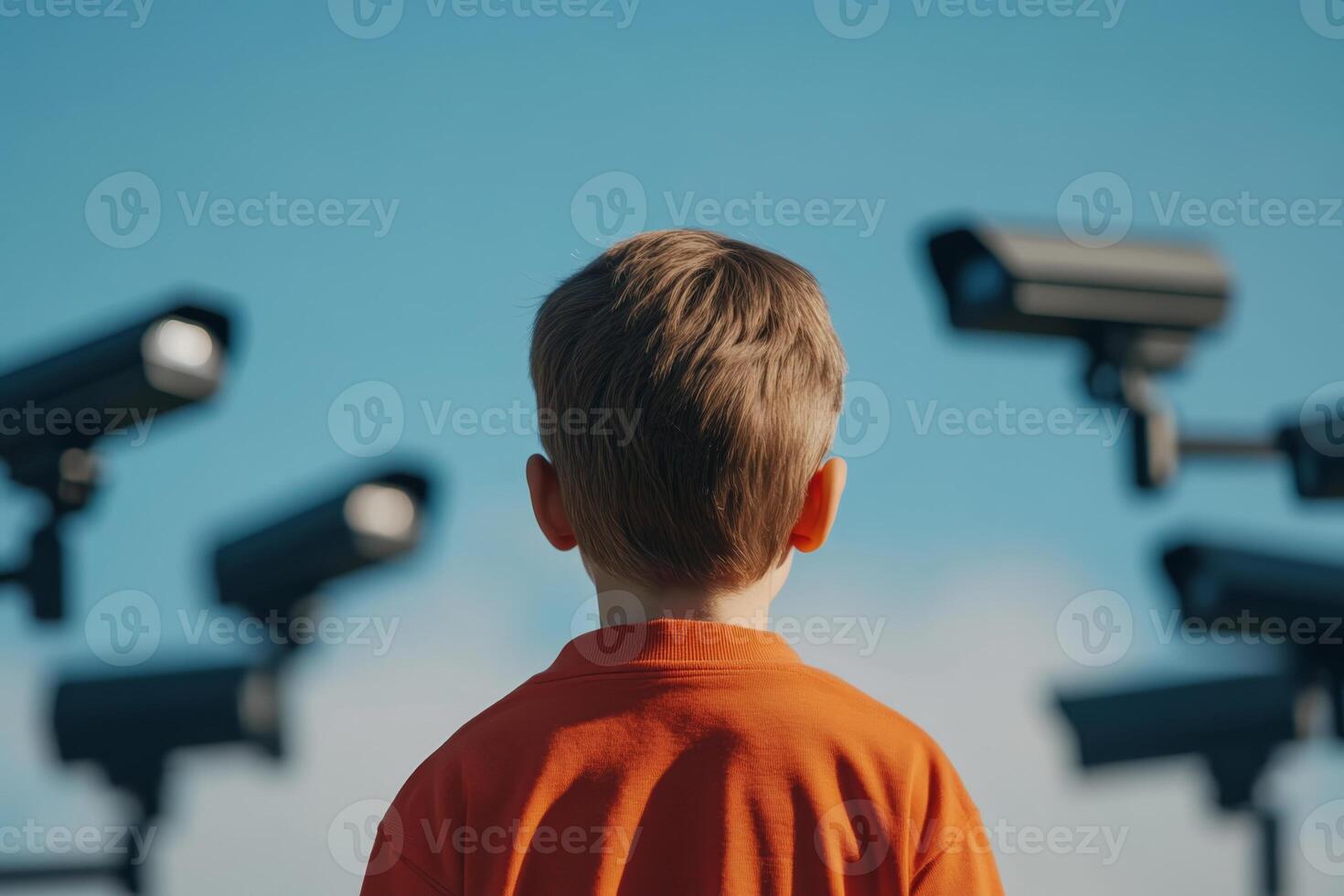 Young boy observing multiple security cameras in a surveillance-rich environment during daytime. Digital slavery, digital concentration camp photo