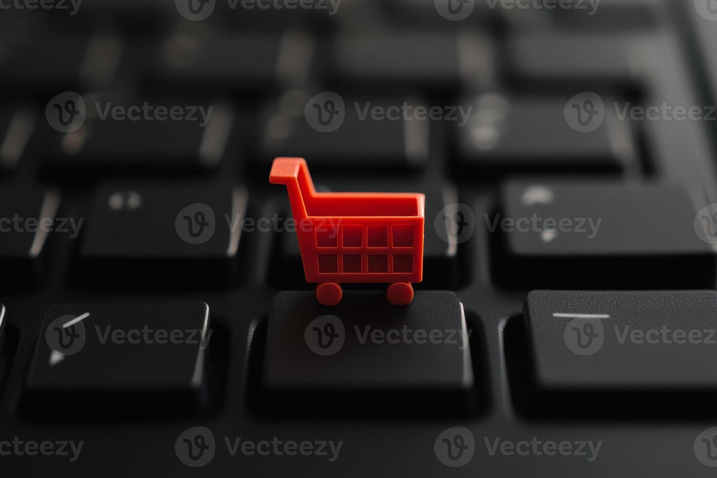 Small red shopping cart on black keyboard brings e-commerce into focus photo
