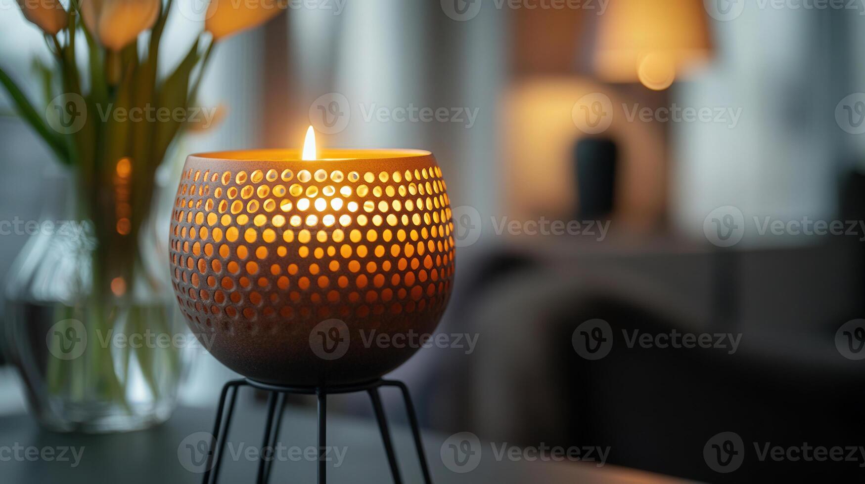 A candle is lit in a vase on a table photo