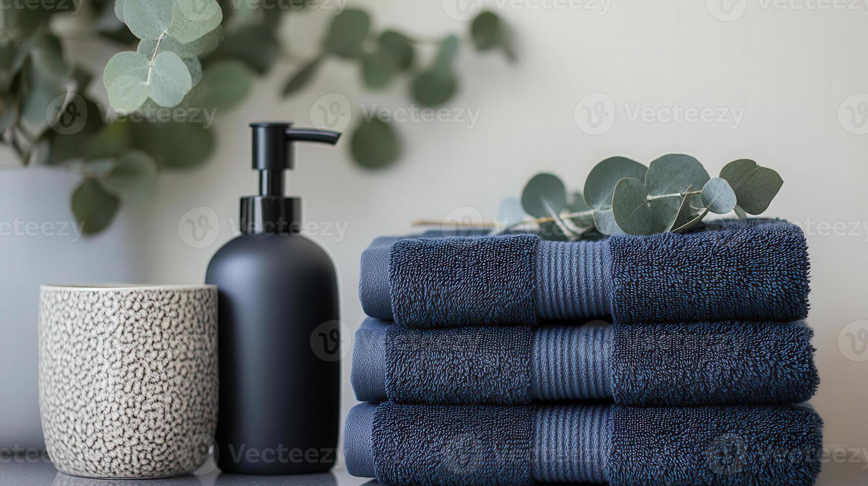 a stack of towels and a bottle of soap and eucalyptus sprigs photo