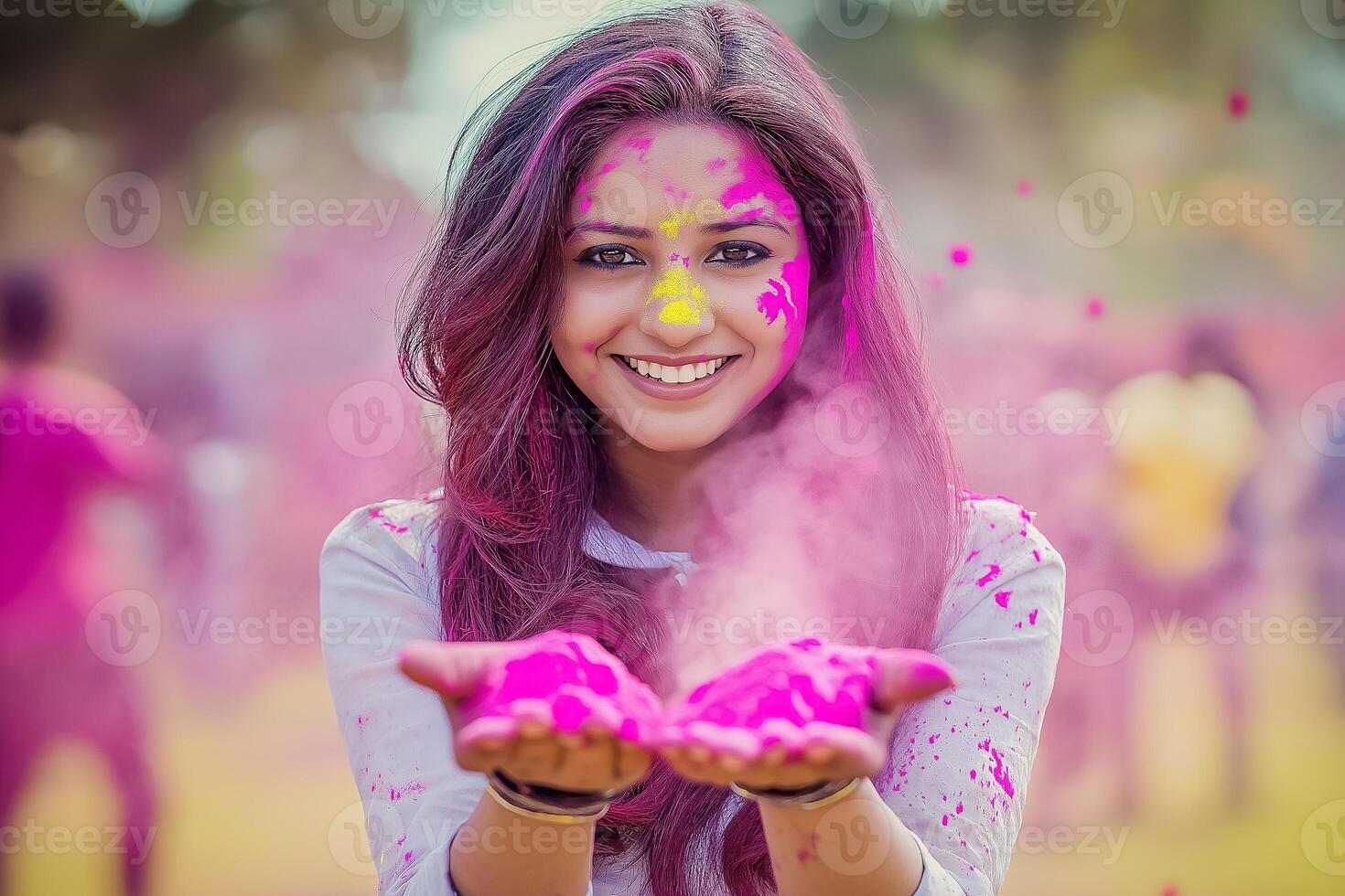 An Indian woman smiles and holds a handful of bright Holi powder in her palms photo