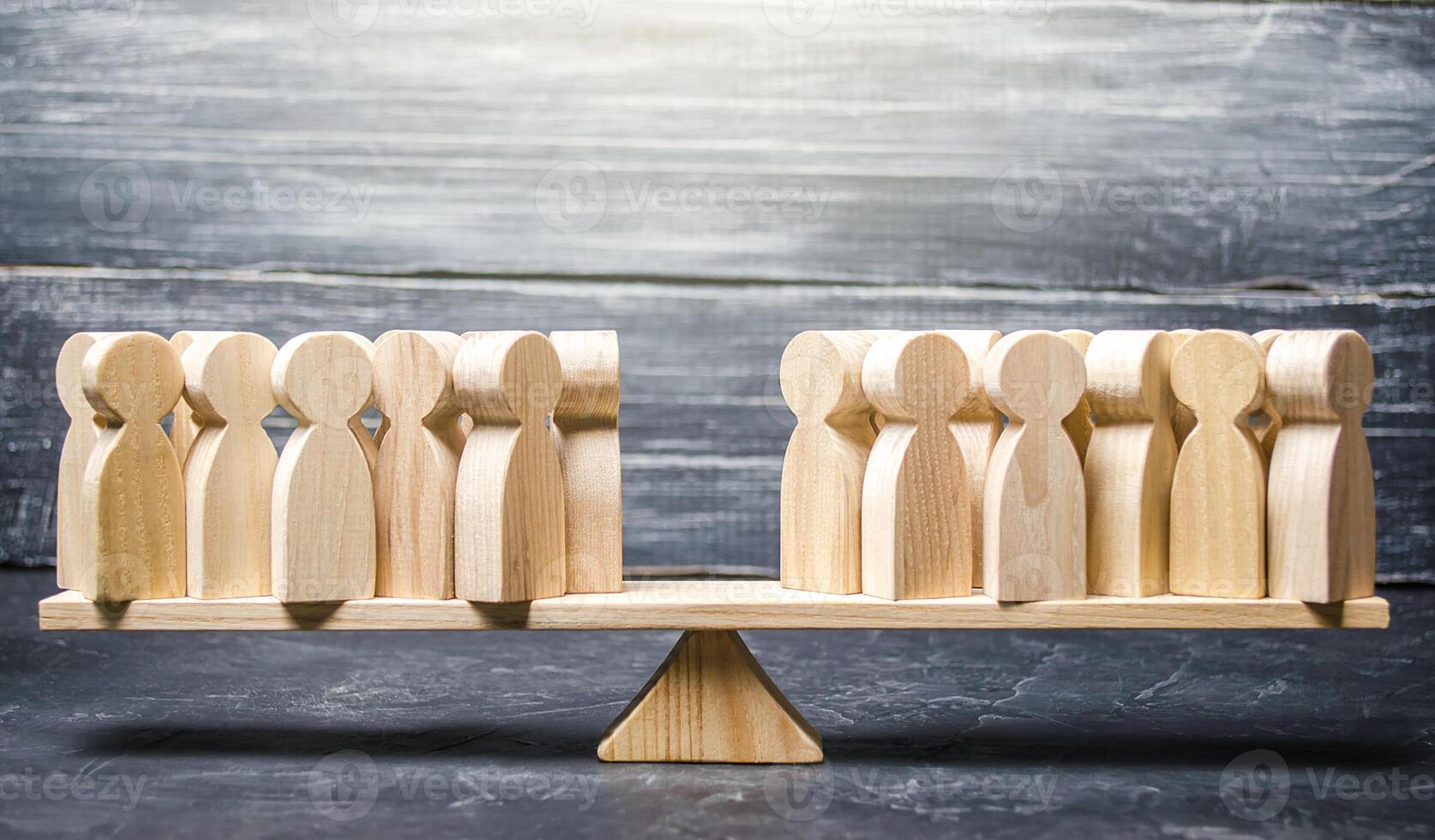 Two groups of people on the scales. Two groups of people on the back of the scale. Different opinions, opposition and opposition in society. Disagreement. Declining more people to their side. photo