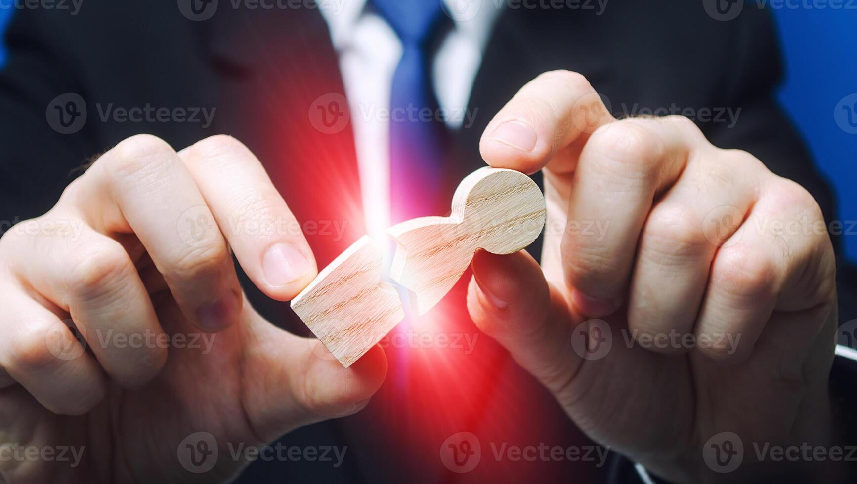 Man breaks apart a human figure. Stress physical exhaustion, strong pressure. Excessive exploitation. Enmity and revenge, causing damage to employee. Dismissal from work. Destructive influence photo