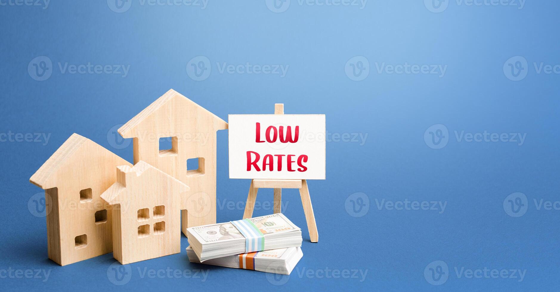 Figurines of houses and an easel with low rates. Low demand for real estate and housing, economic downturn and recession. Generous promotions and discounts on home sales. Special purchase offers photo