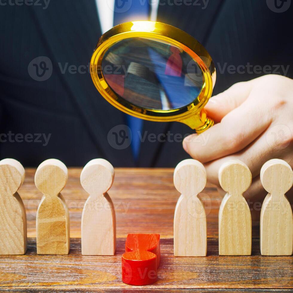 Man studies a fallen red man. Moral and physical exhaustion, weak link. Dismissal employee. Toxic ineffective worker. Burnout at work. Optimization, performance evaluation. Severe working conditions. photo