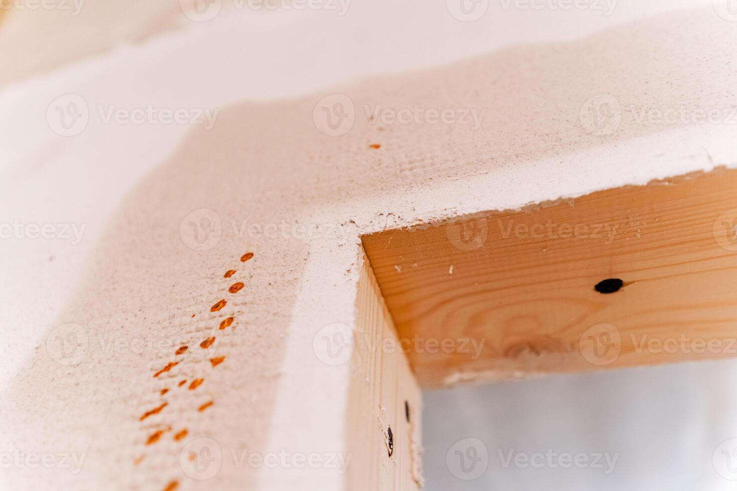 This image showcases a detailed closeup view of a wooden beam that has been adorned with a coat of white paint, highlighting the texture and craftsmanship of the wood itself photo