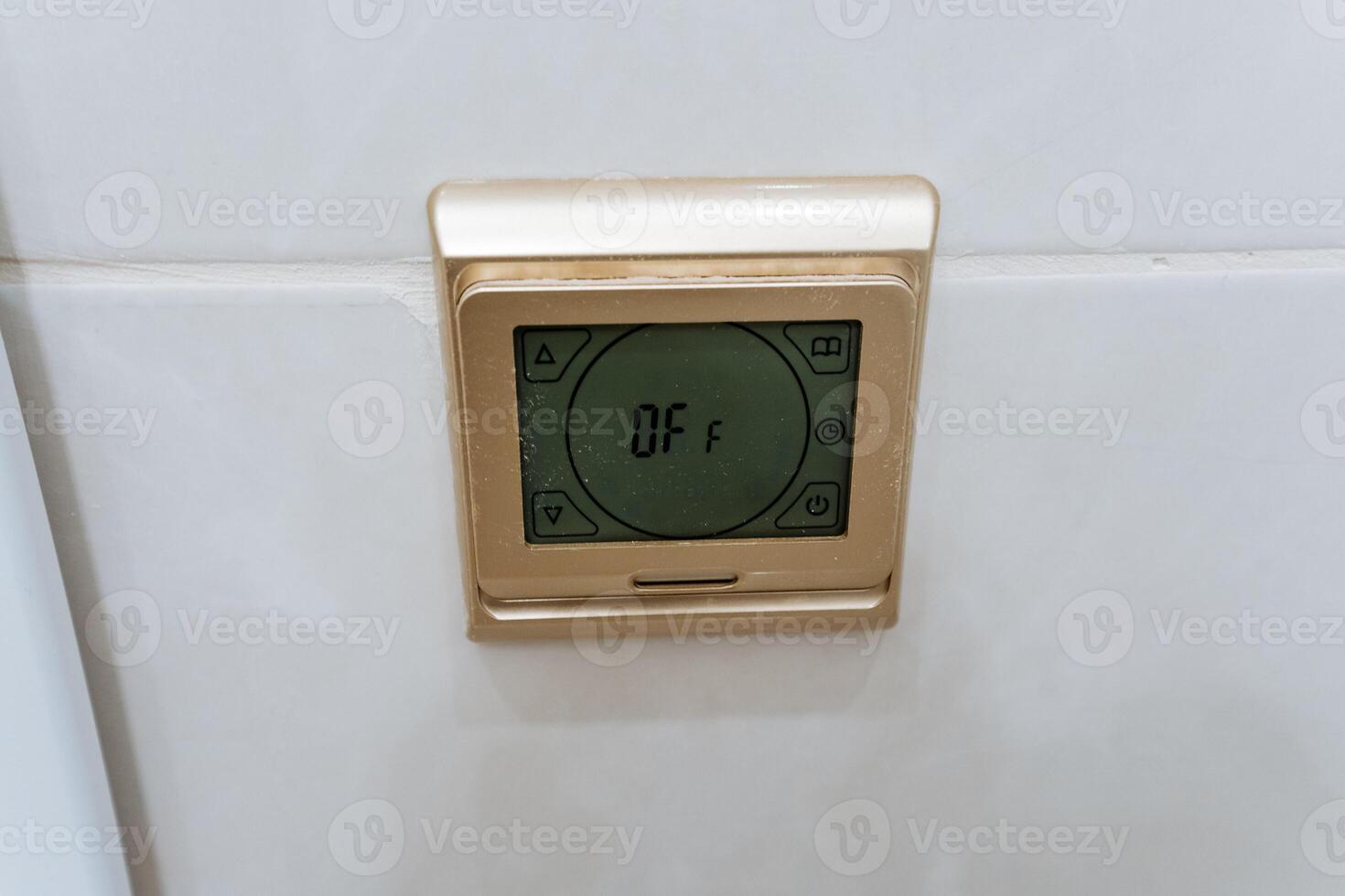 A sleek and modern digital thermostat is noticeably mounted on a pristine, white wall, effectively highlighting its advanced design and multifunctionality within this contemporary space photo