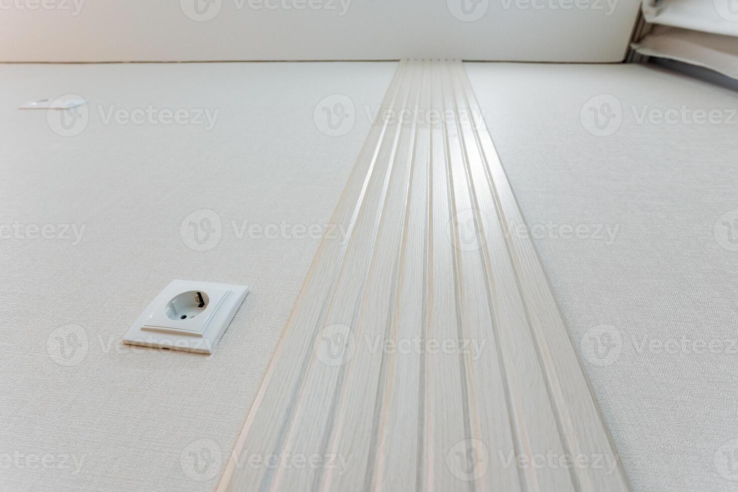 Next to the electrical socket, the immaculate white stripes on the floor serve to significantly enhance the cleanliness and aesthetic appeal of the entire area, making it more inviting photo