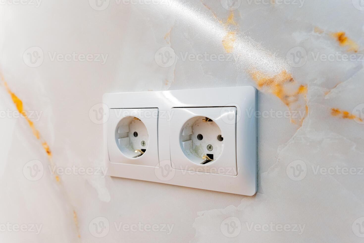 A detailed closeup of a pristine white electrical outlet firmly mounted on a gorgeous marble wall, highlighting the exquisite and intricate texture of the marble in stunning detail photo