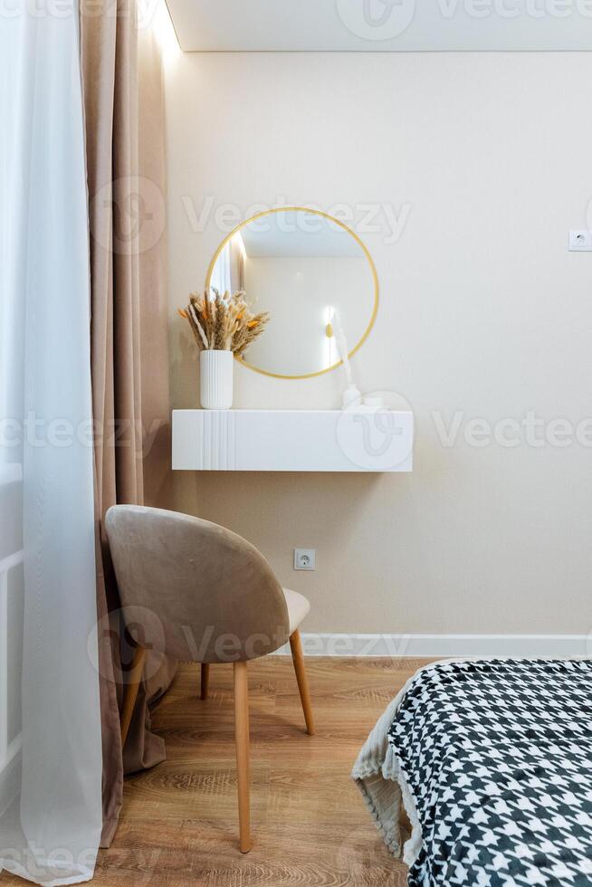 In the cozy bedroom, there is a comfortable chair positioned next to a beautiful mirror, enhancing the rooms charm and functionality, creating a perfect spot for relaxation and reflection photo