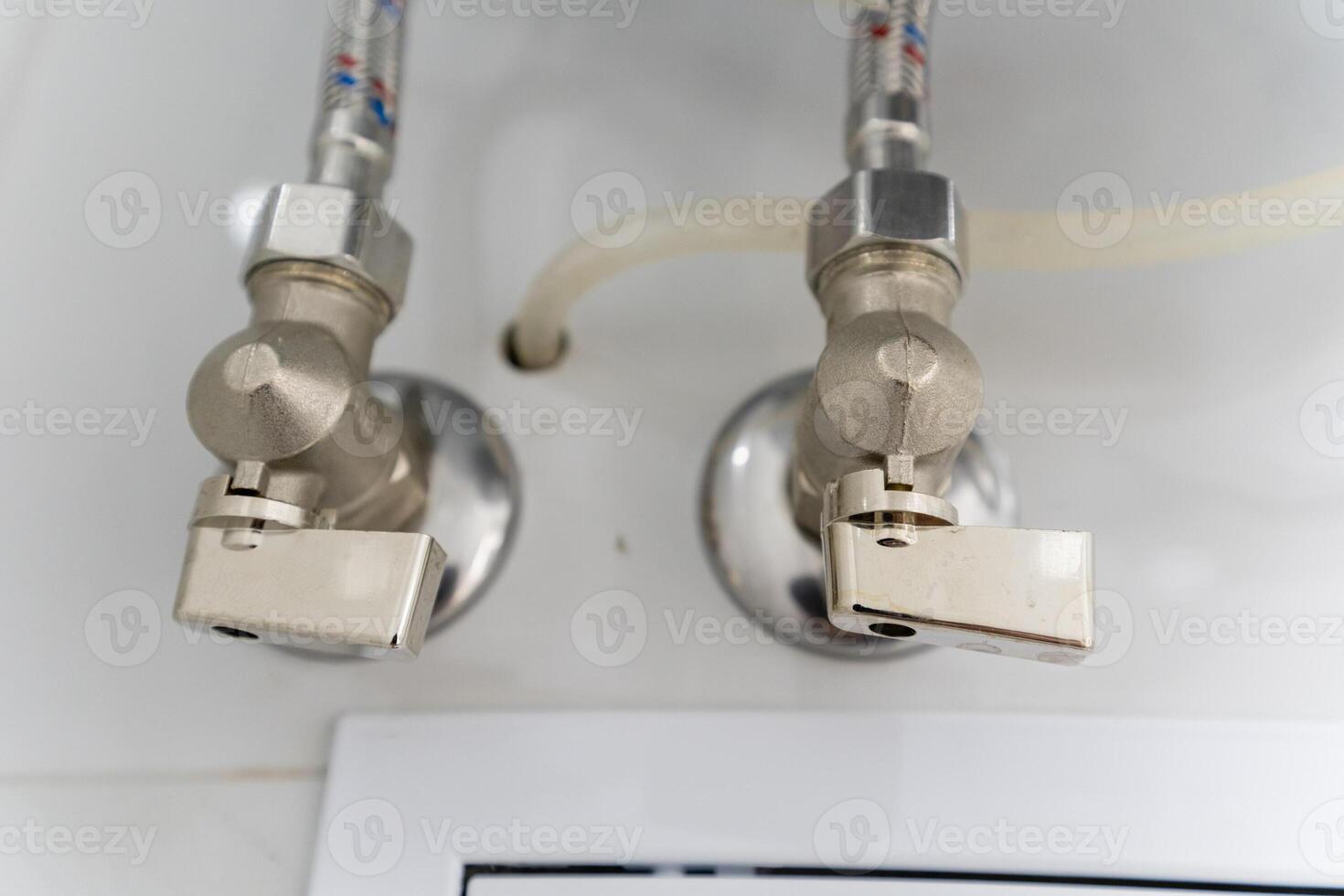 Closeup view of two faucets securely attached to a wall photo