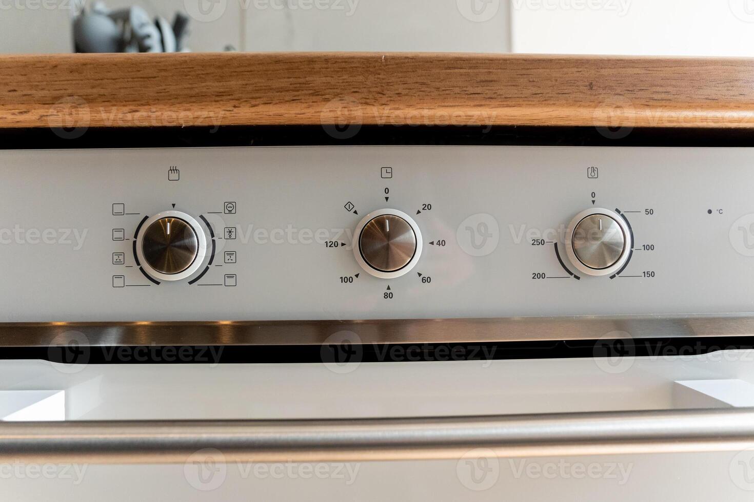 A closeup of a stainless steel oven with three knobs photo