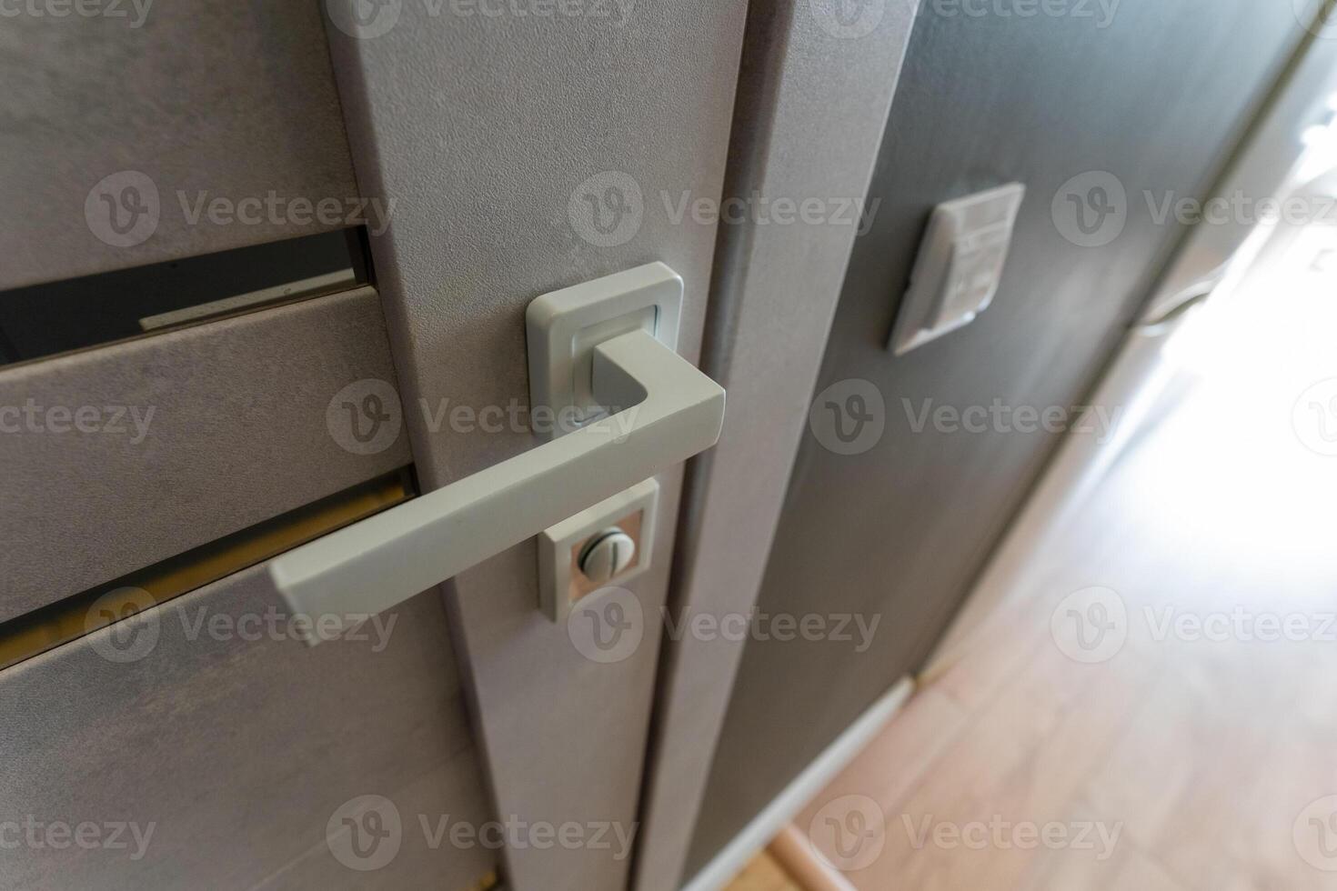 This is a closeup view of a door handle placed upon a door photo