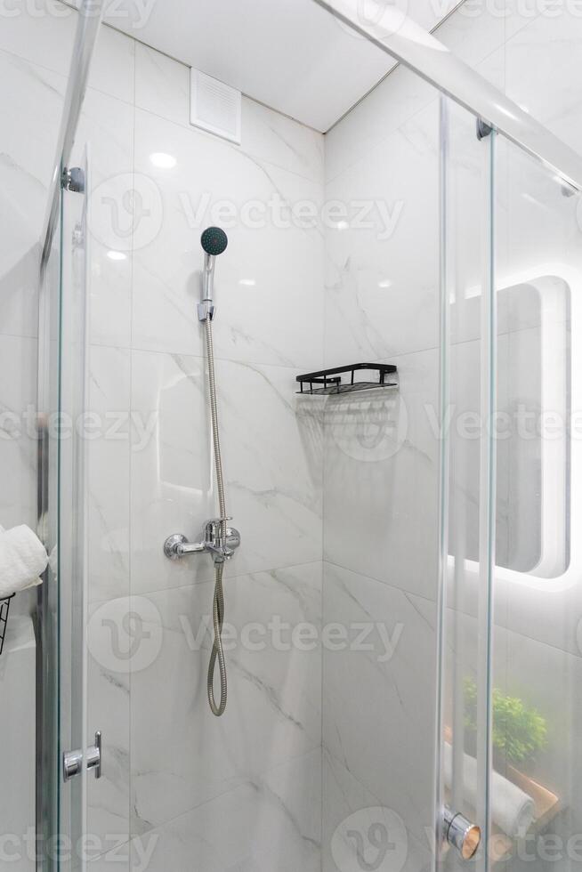 A bathroom that features a shower stall as well as a mirror photo