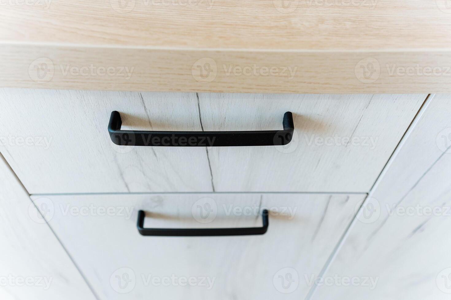Close up of rectangular wooden cabinet with black handles photo