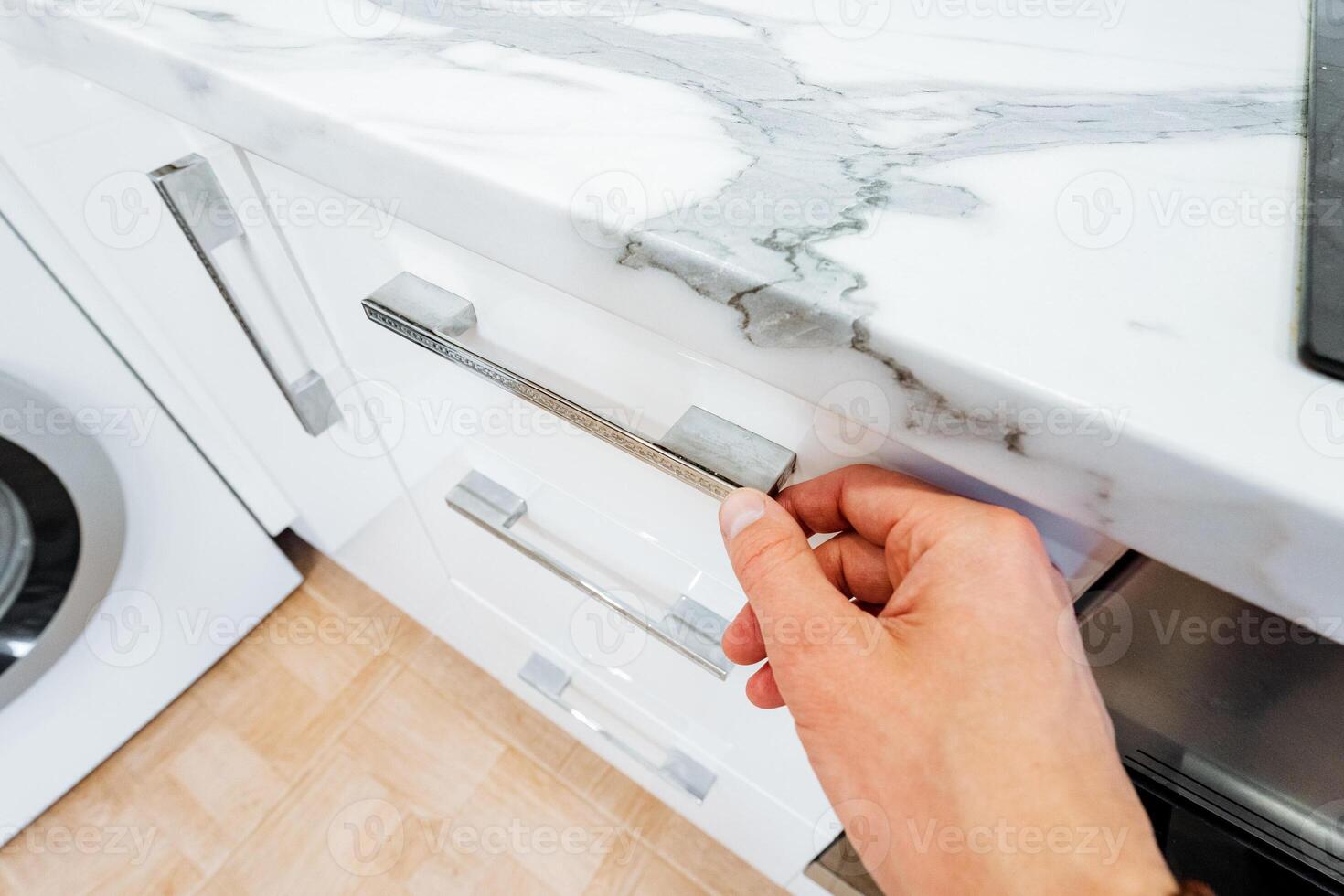 A person opens a drawer in the kitchen with a quick gesture photo