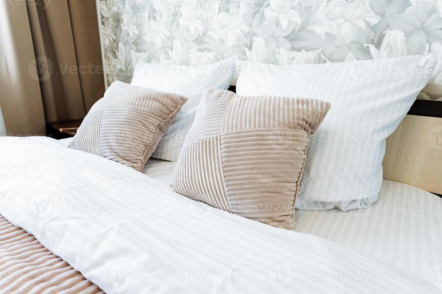 A comfortable bed with white linens in a hotel room with hardwood flooring photo