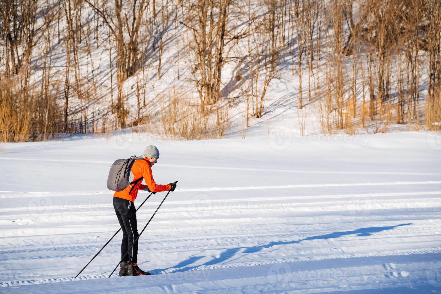 Man skiing with backpack on snowy slope. Winter sport photo