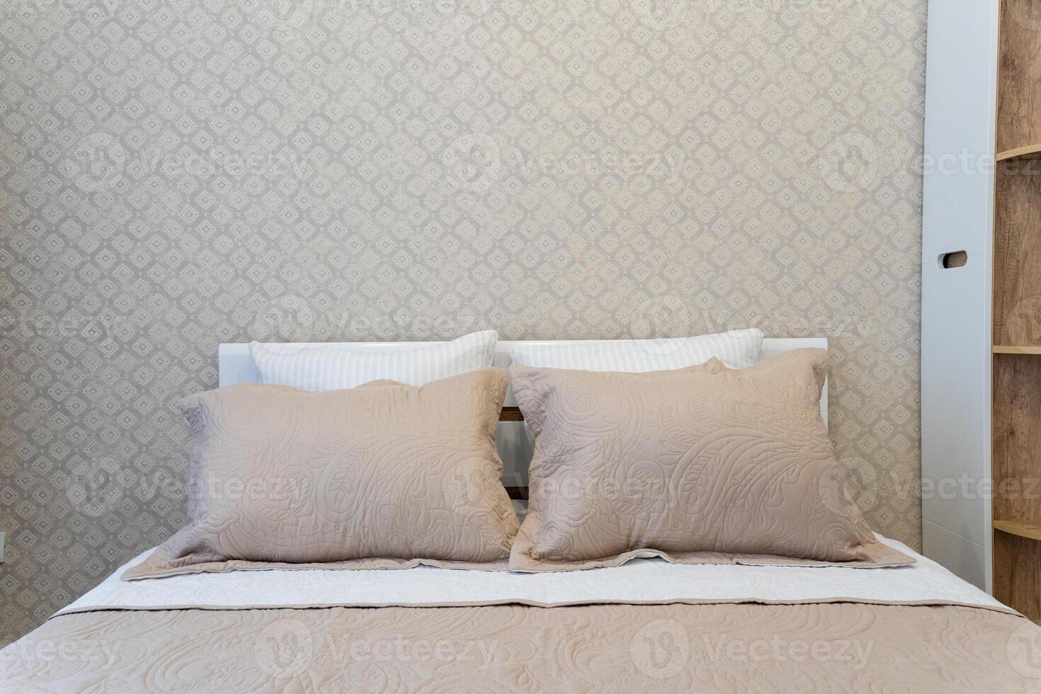 In a beautifully decorated bedroom, there is a cozy bed that features a lovely white headboard complemented by soft and inviting beige pillows, creating a serene atmosphere photo