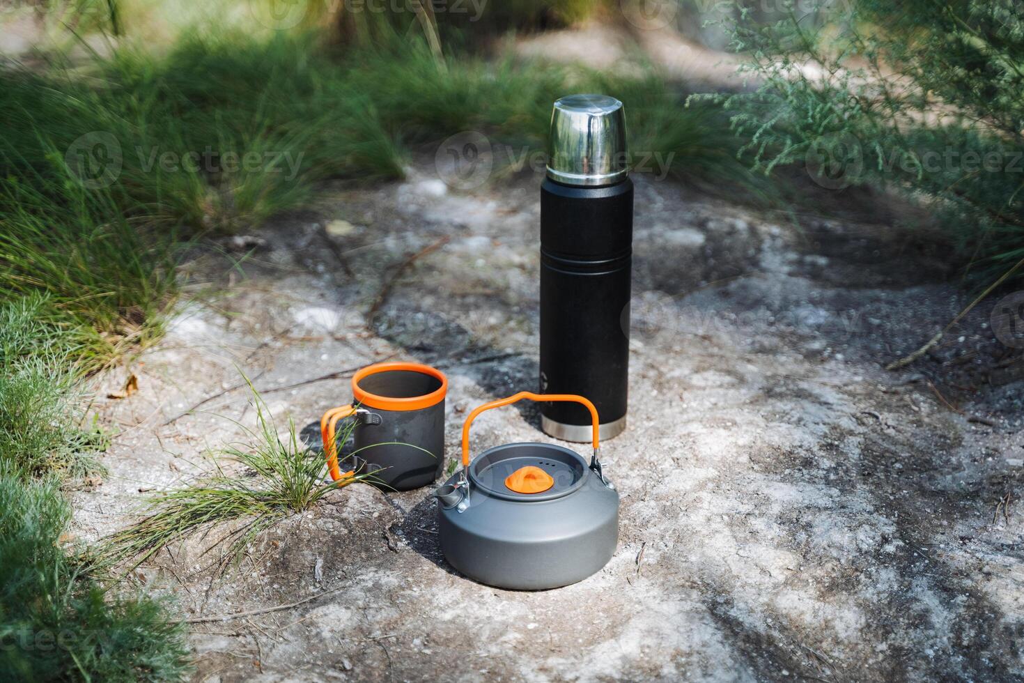 When going camping, its important to have a thermos, kettle, and mug for hot drinks. Stay hydrated and enjoy the beautiful scenery around you while on outdoor adventures photo