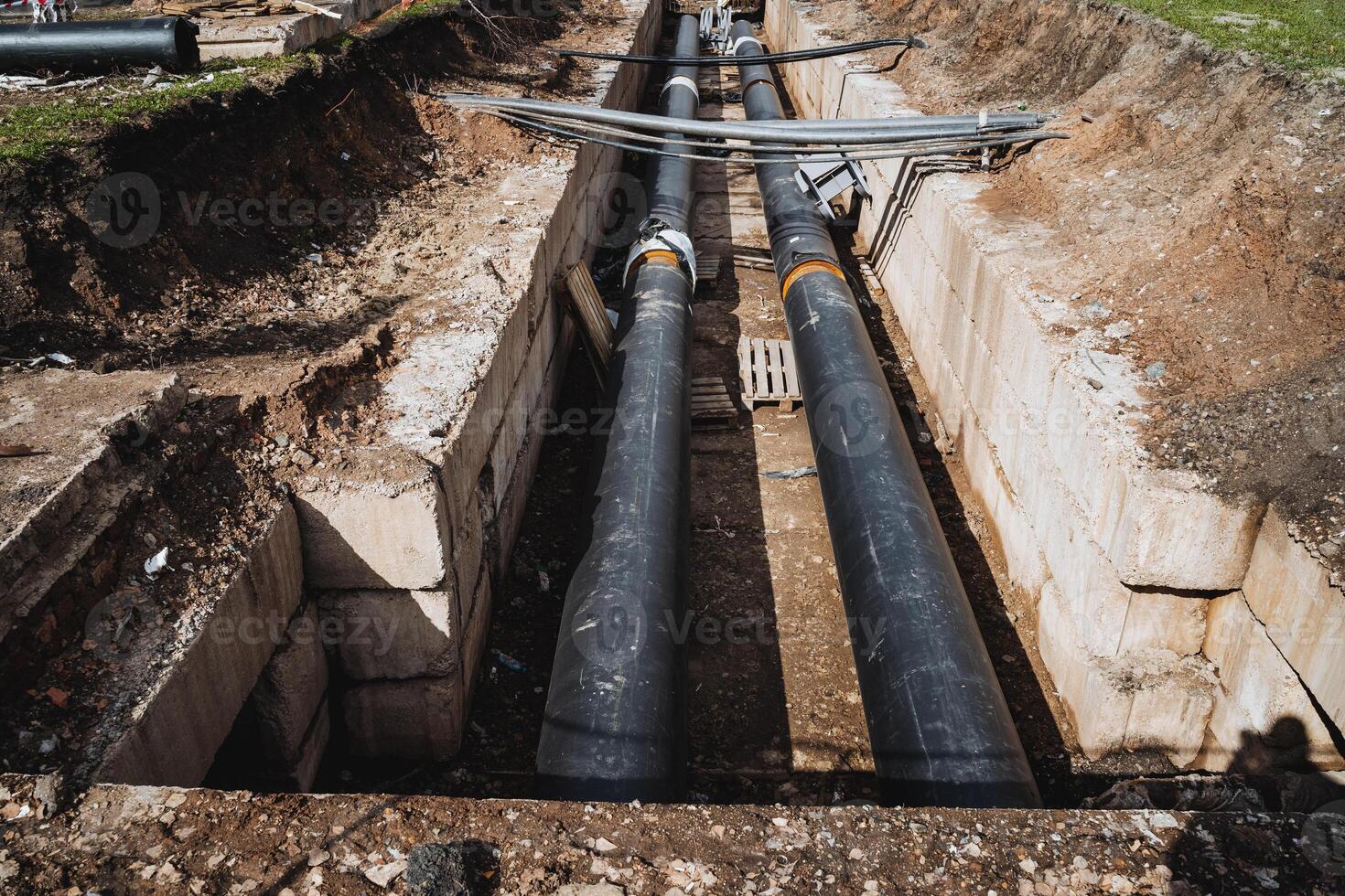 Pipes made of metal are being installed in a trench photo