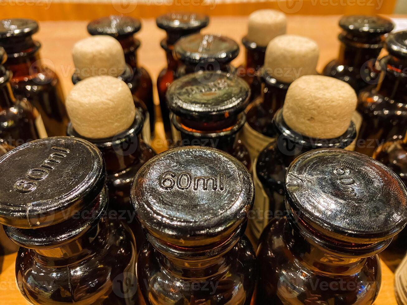 Among the truly diverse and varied collection of bottles, one distinct and unique bottle clearly stands out with a prominently displayed label indicating its capacity of 60ml of liquid photo