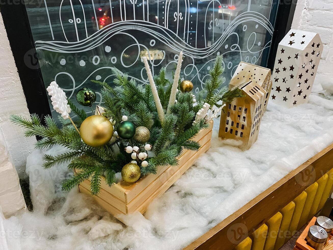 On a window sill, there is a charming wooden box that is filled to the brim with festive Christmas decorations, just waiting to bring holiday cheer into the home this season photo