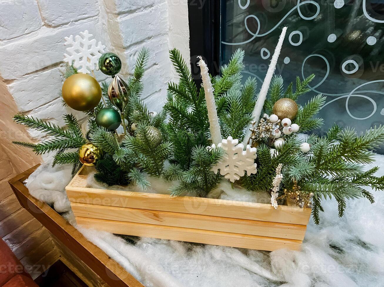 A beautifully crafted wooden box that is filled with an array of colorful and festive Christmas decorations is sitting elegantly on a cozy window sill, brightening up the room photo