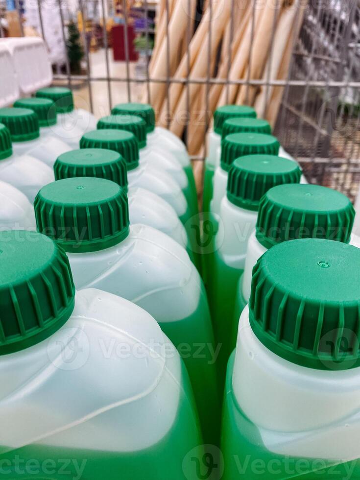 You can observe a row of distinct green and white bottles that feature green lids, showcasing their unique design and functionality, perfect for containing various types of liquids photo