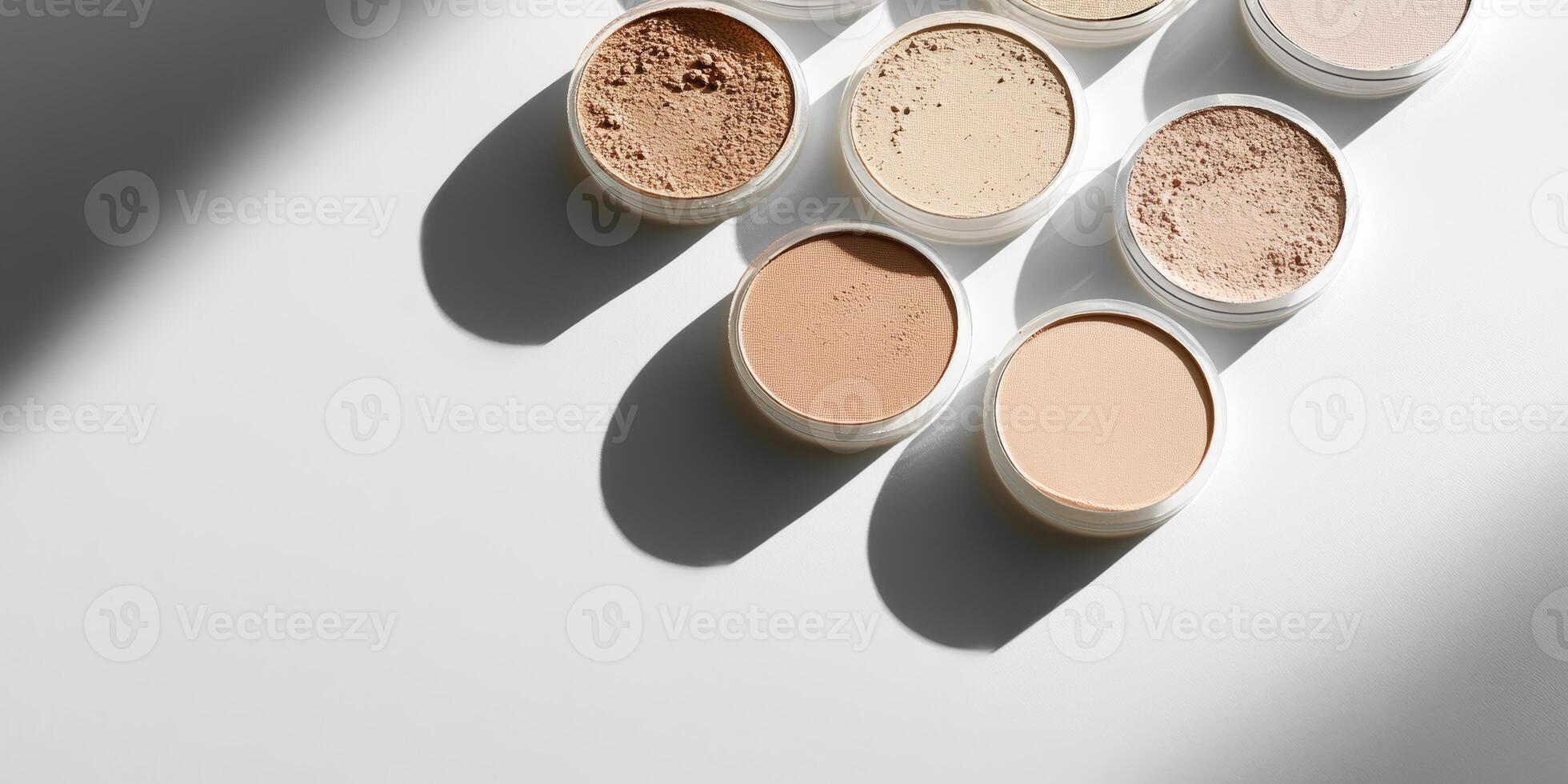Compact powder arranged neatly on a white surface, casting a soft shadow. photo