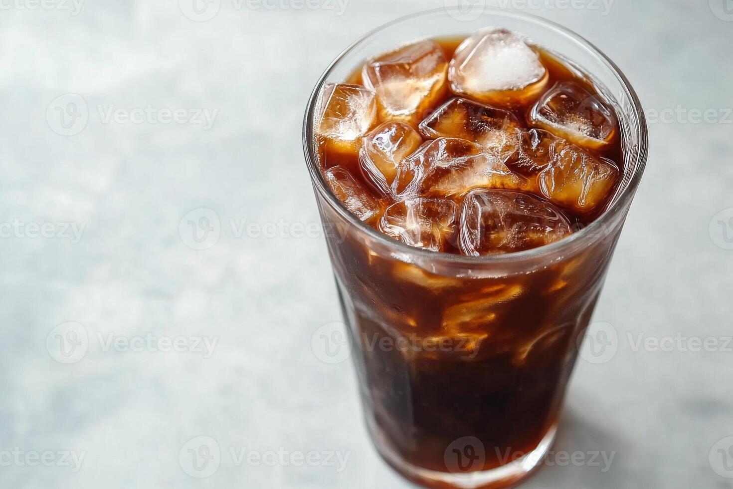 A glass of iced coffee with ice cubes in it. photo