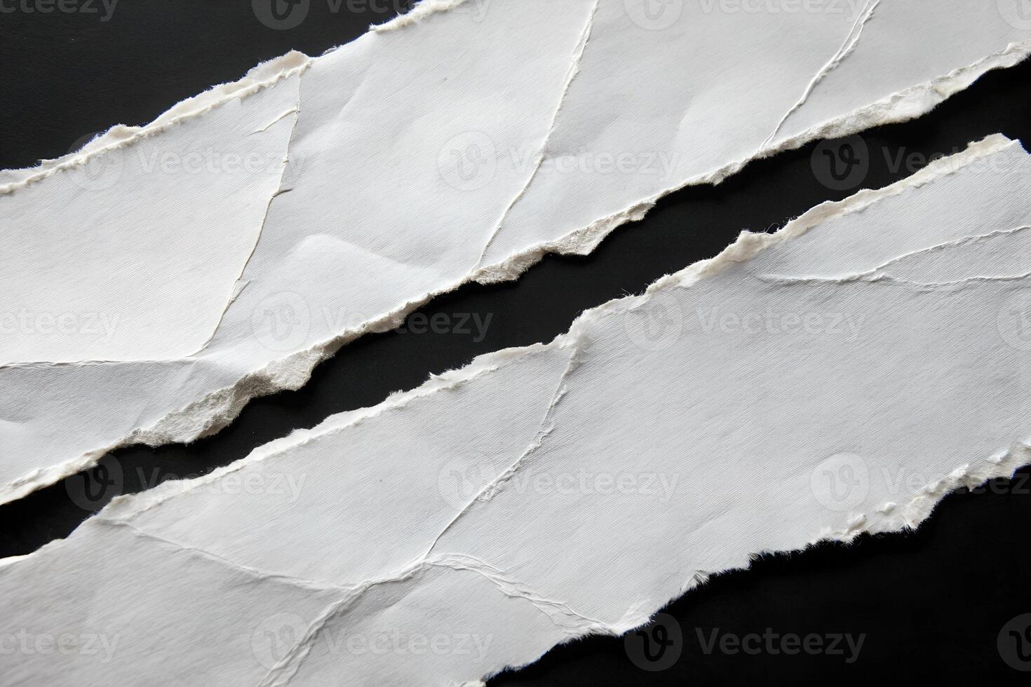 Small Ripped White Torn Paper Edges Isolated on Black Background photo