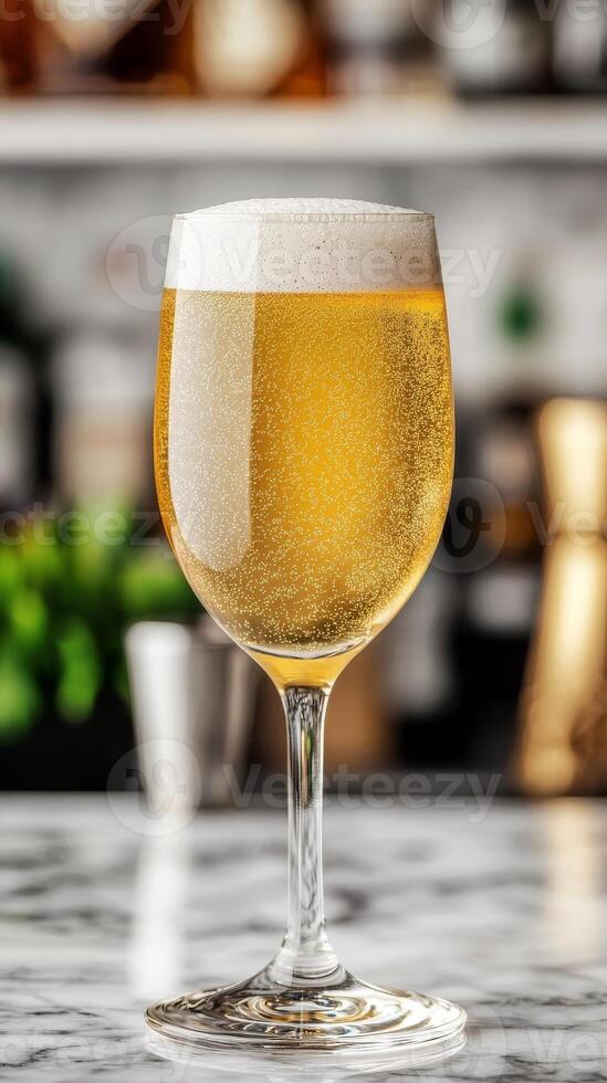 Shimmering cocktail glass. A chilled glass of beer with foam on a marble countertop. photo