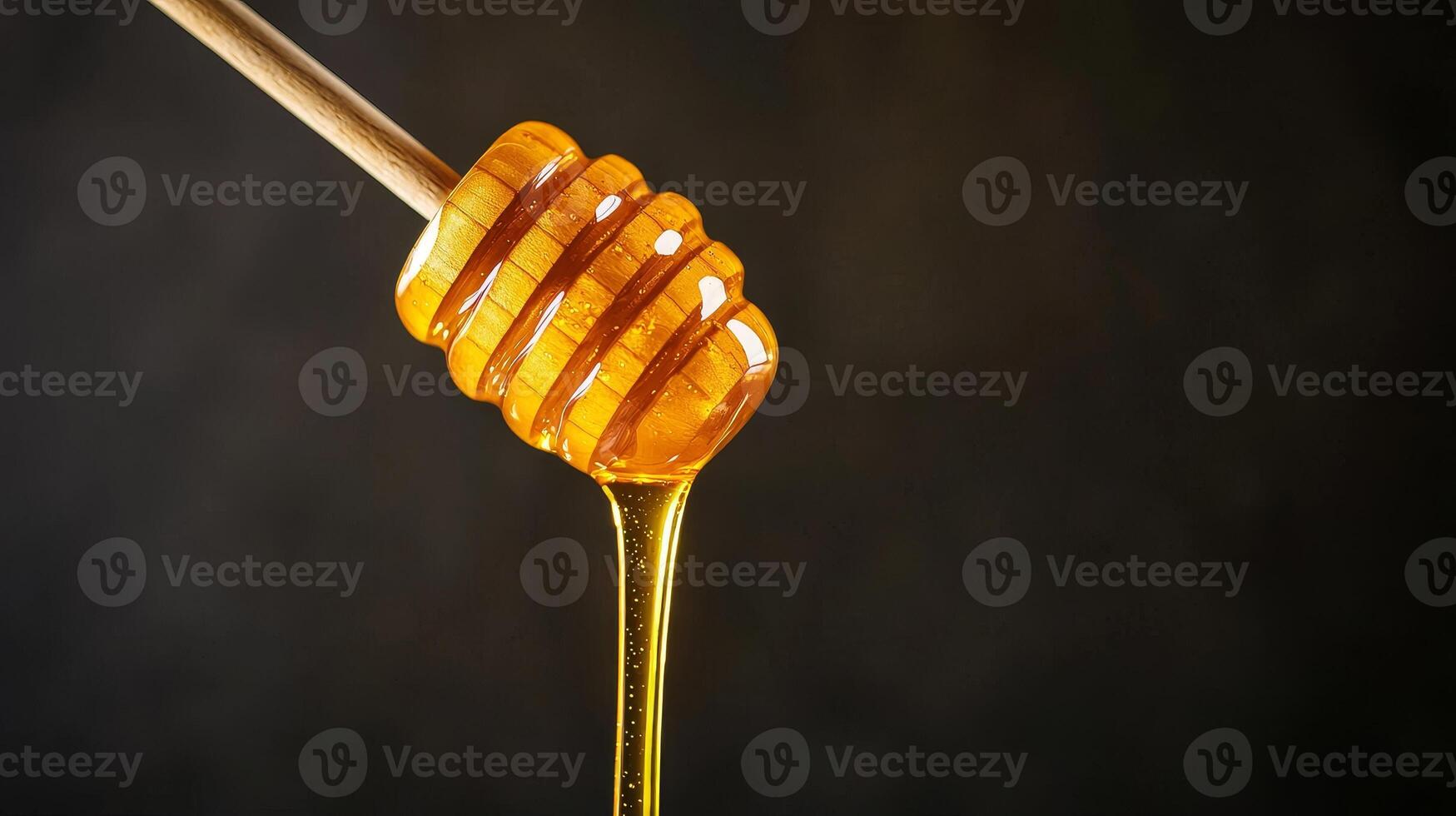 Honey dipping stick. Golden honey dripping from a wooden dipper against a dark background. photo