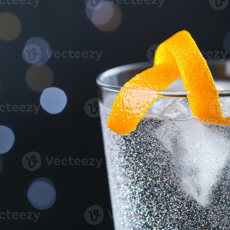 Shimmering cocktail glass. Refreshing drink with orange peel against a bokeh background. photo