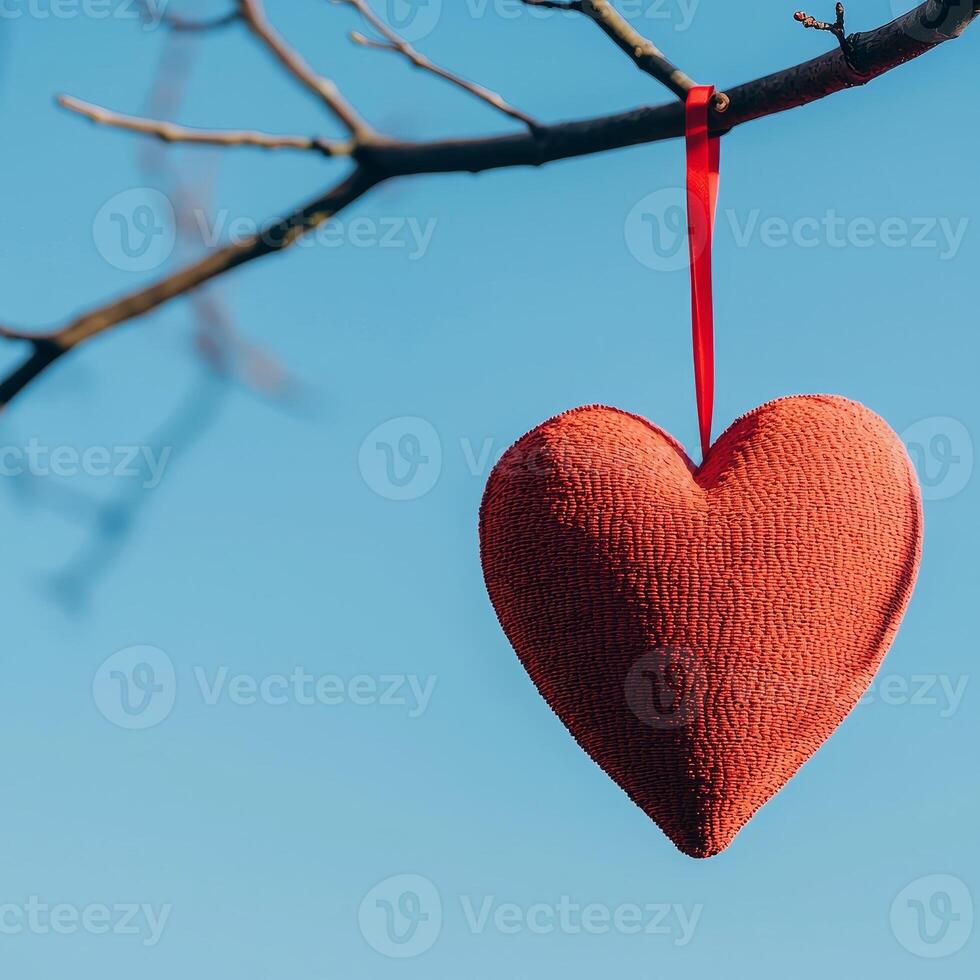 Grateful love prayers for valentine's day concept. Hanging heart decoration on a tree branch against a blue sky. photo