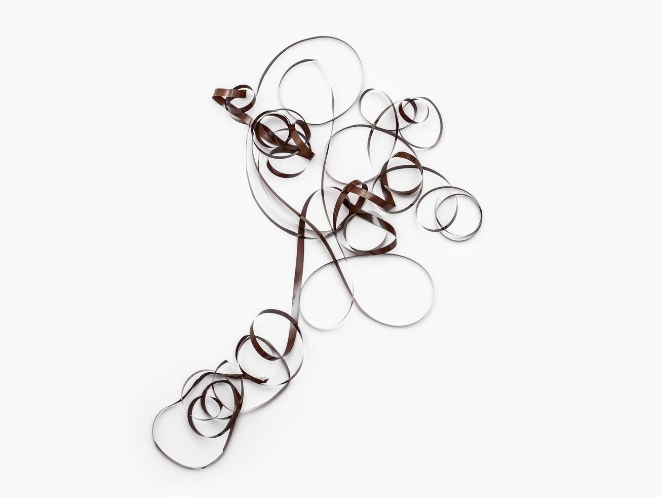 a piece of audio magnetic tape tangled on white background photo