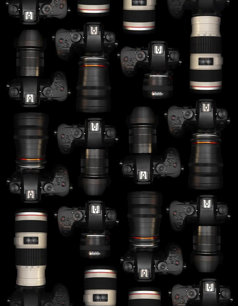 Mirrorless Cameras with different lenses for shooting videos. Top view of digital cameras isolated on black background photo