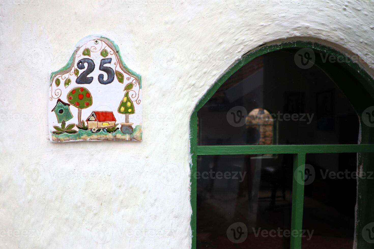 The charming and inviting House Number 25 is beautifully displayed on a white wall photo