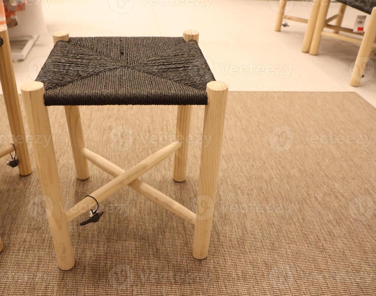 This is a Stylish Wooden Stool featuring a Black Woven Seat that enhances any space photo