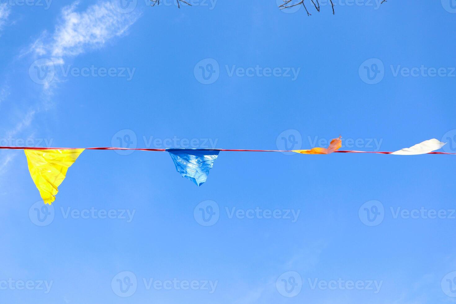 Vibrant and Colorful Flags Are Flapping Gracefully Against a Bright and Clear Blue Sky Above Us photo