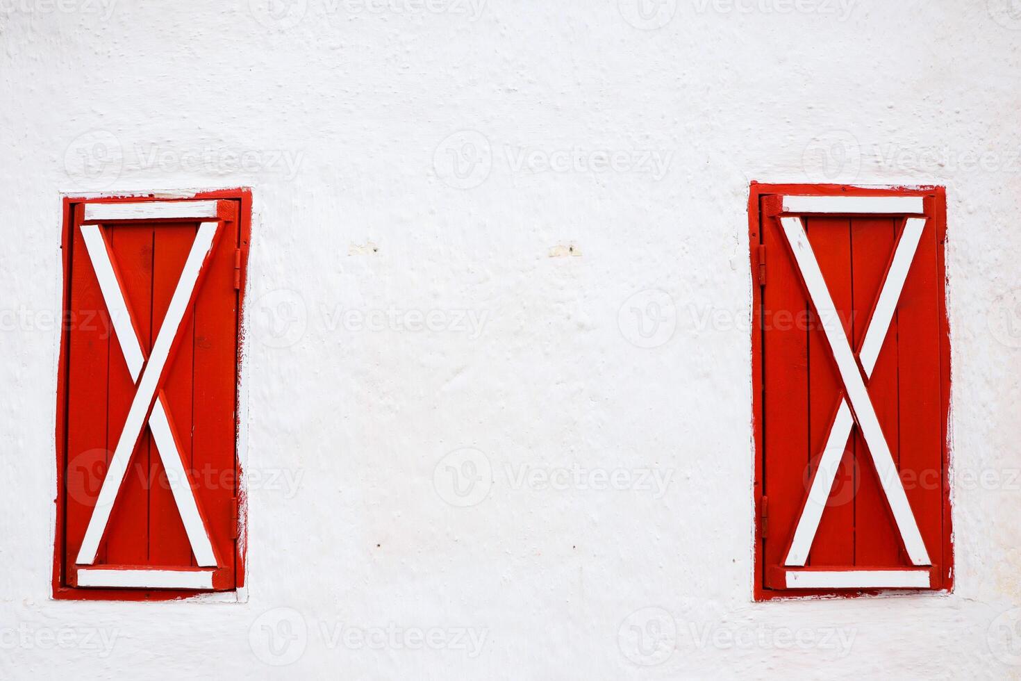 Charming and Elegant Red and White Window Shutters Gracefully Adorning a Crisp White Wall photo