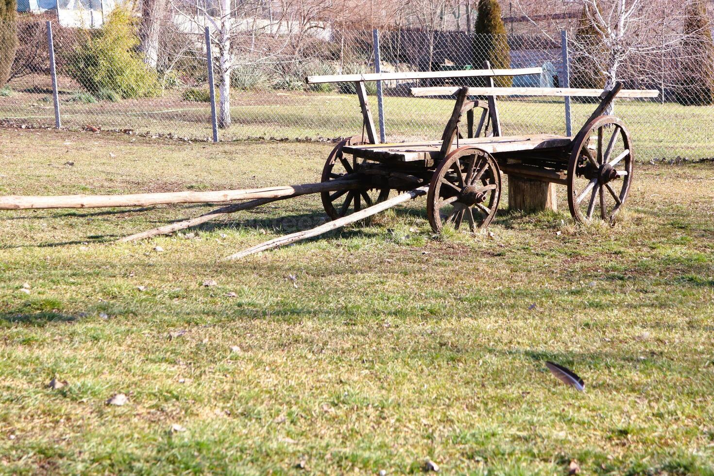 A rustic wooden cart stands proudly in a vibrant green meadow, adding charm to the landscape photo