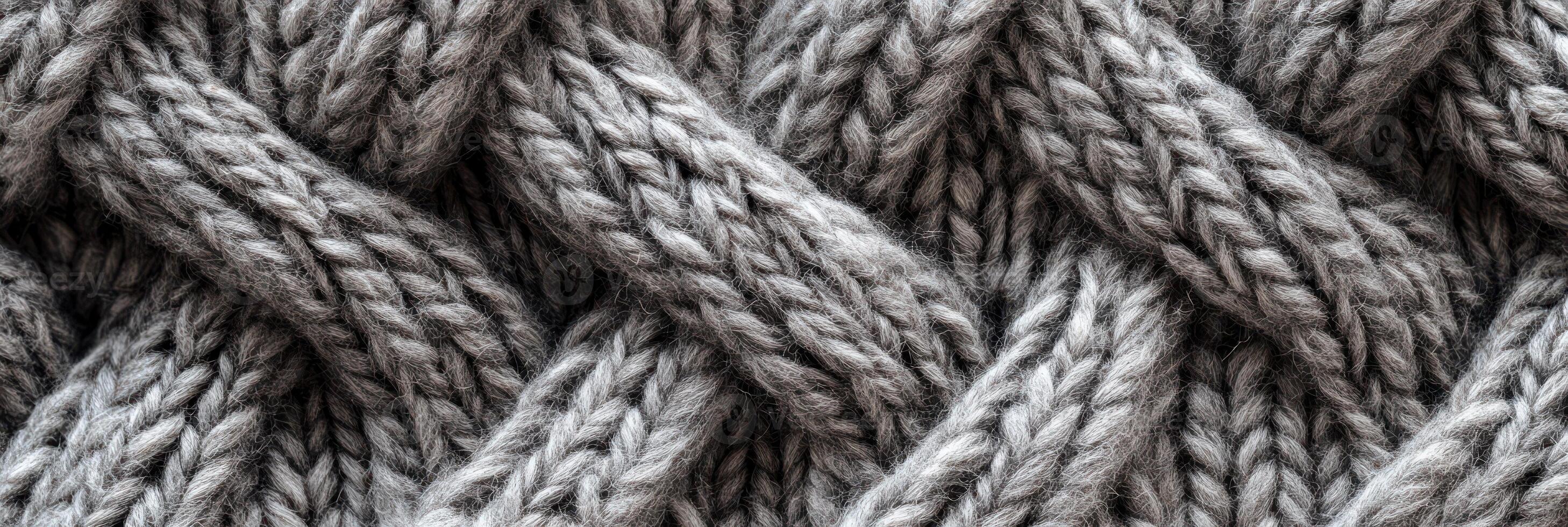 Close-up of gray woolen knitted fabric texture with braided pattern photo