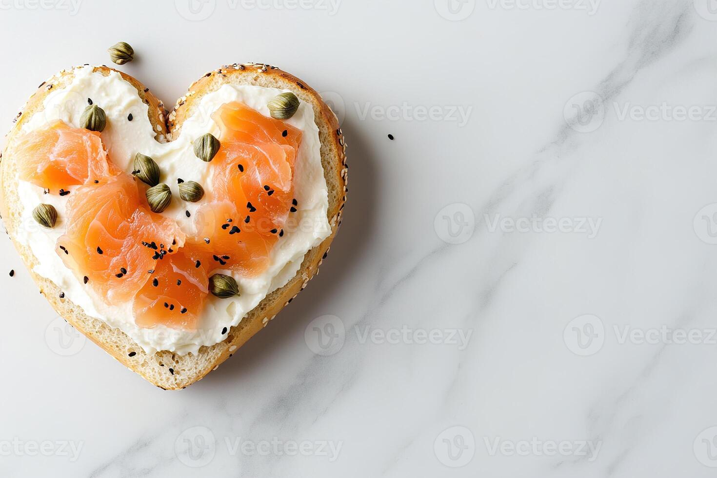 A heart-shaped bagel features a generous layer of cream cheese, adorned with slices of smoked salmon and capers, set against a light marble background with plenty of space for text photo
