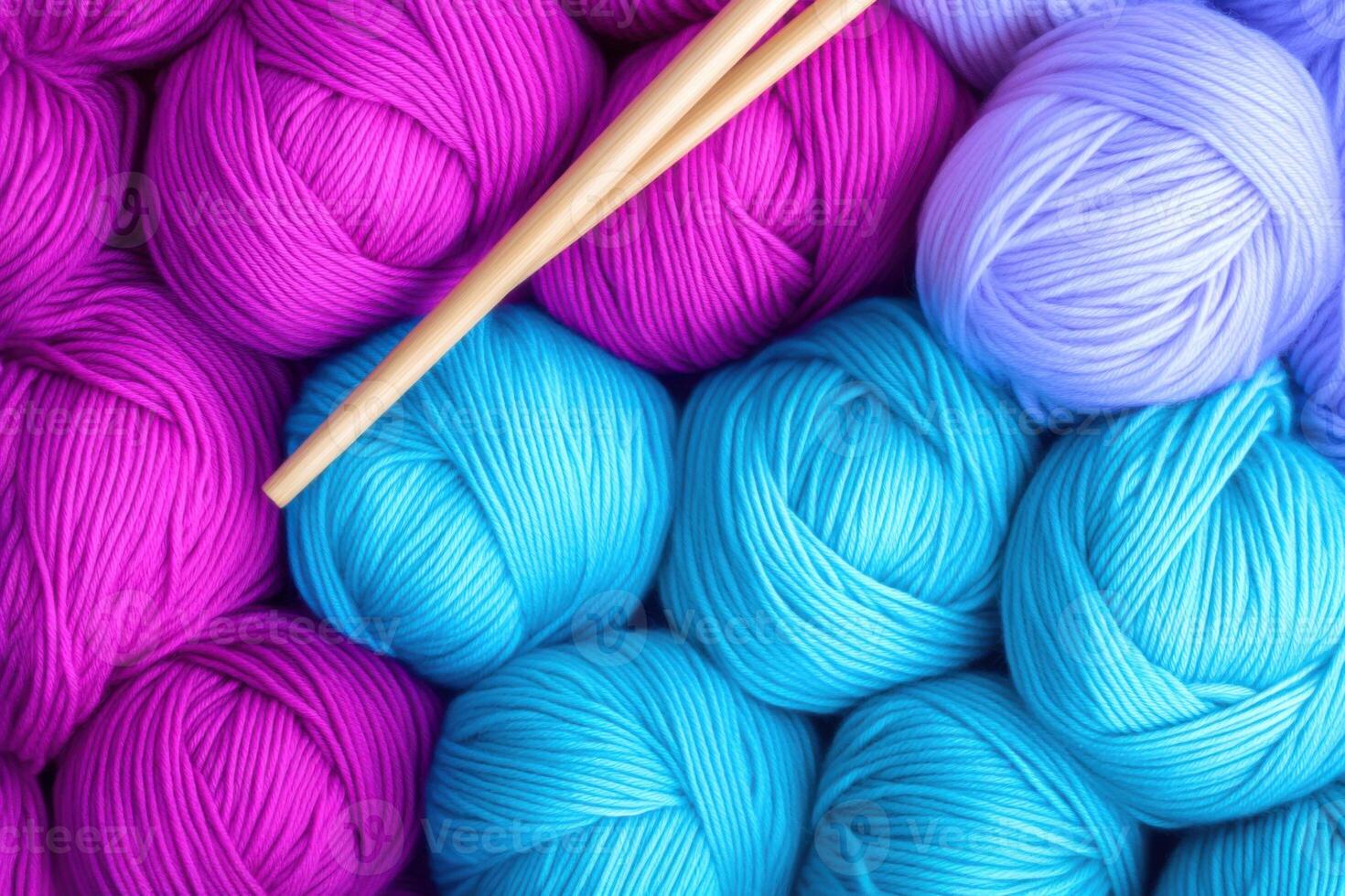 Explore colorful knitting supplies with vibrant yarn balls in magenta, turquoise, and pastel blue alongside wooden knitting needles photo