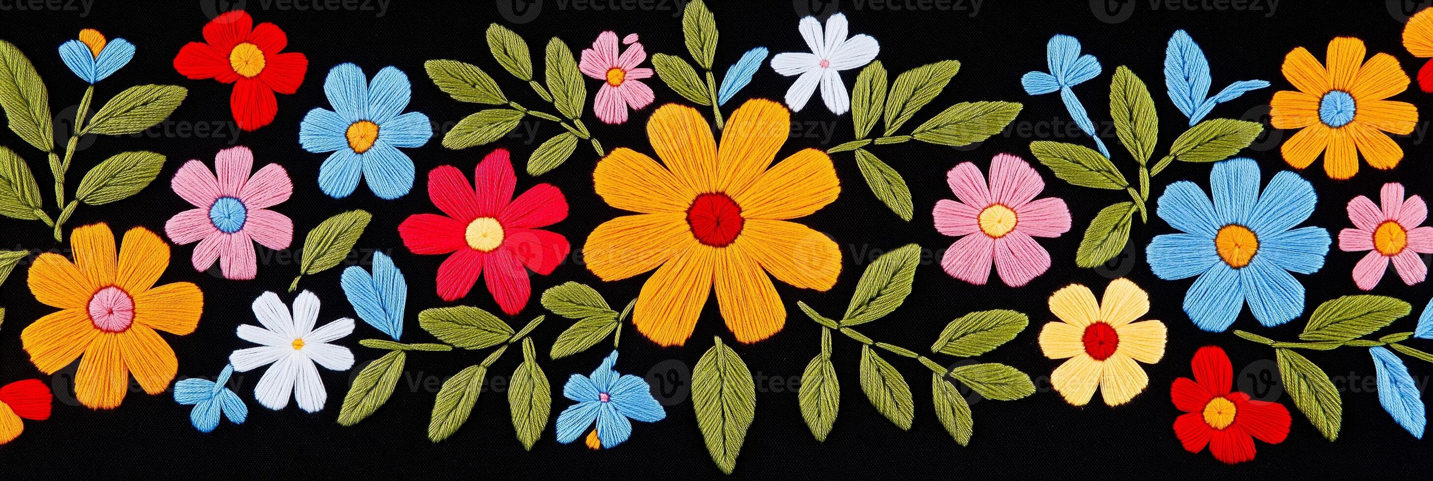 Colorful Oaxaca-style embroidery pattern featuring vibrant flowers and geometric shapes on black fabric photo