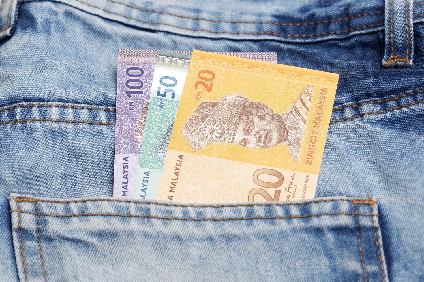 Malaysian ringgit in the pocket of blue jeans photo