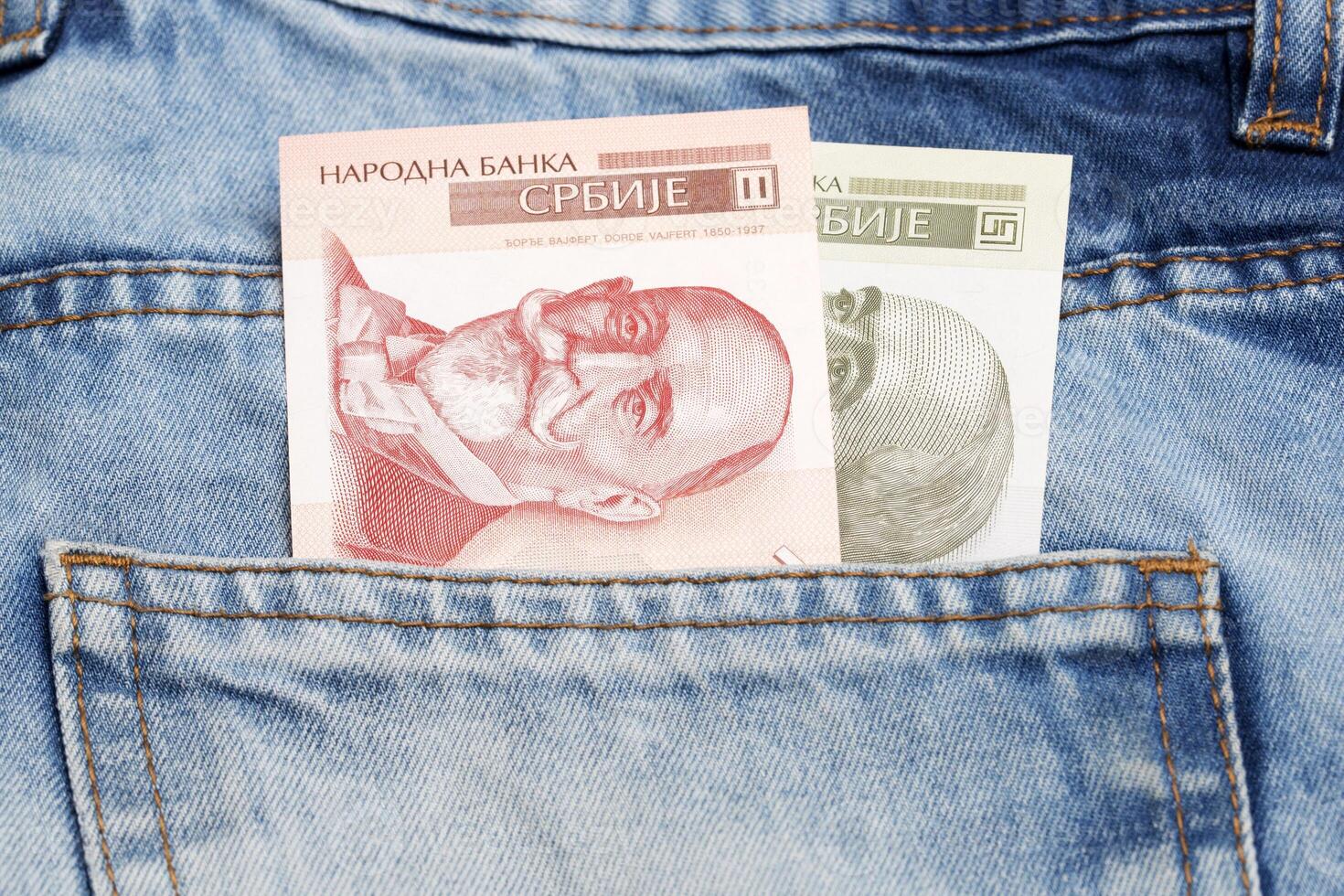 Serbian dinar in the pocket of blue jeans photo